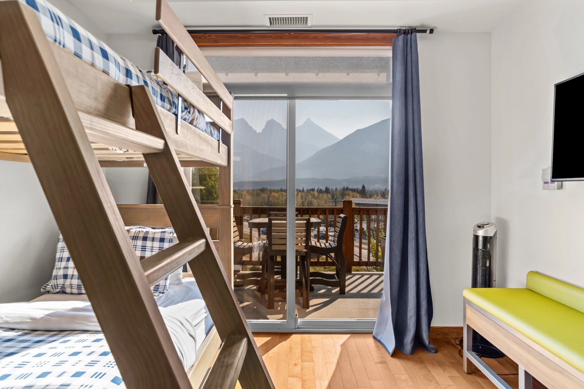 Bunk beds face sliding glass doors opening to a balcony with mountain views.