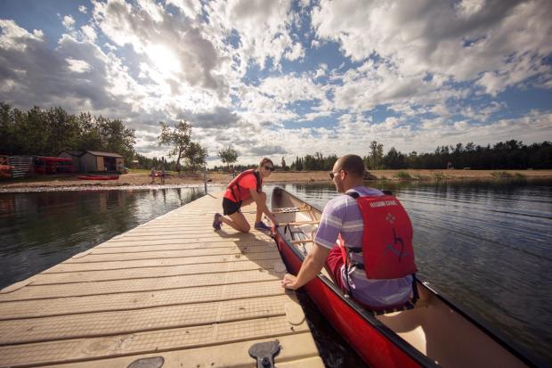 Couple getting ready go canoeing on Astotin Lake in Elk Island National Park.