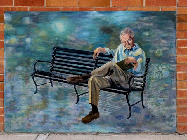 Sepia mural of historical figures crafting, with handwritten text and vintage portrait.