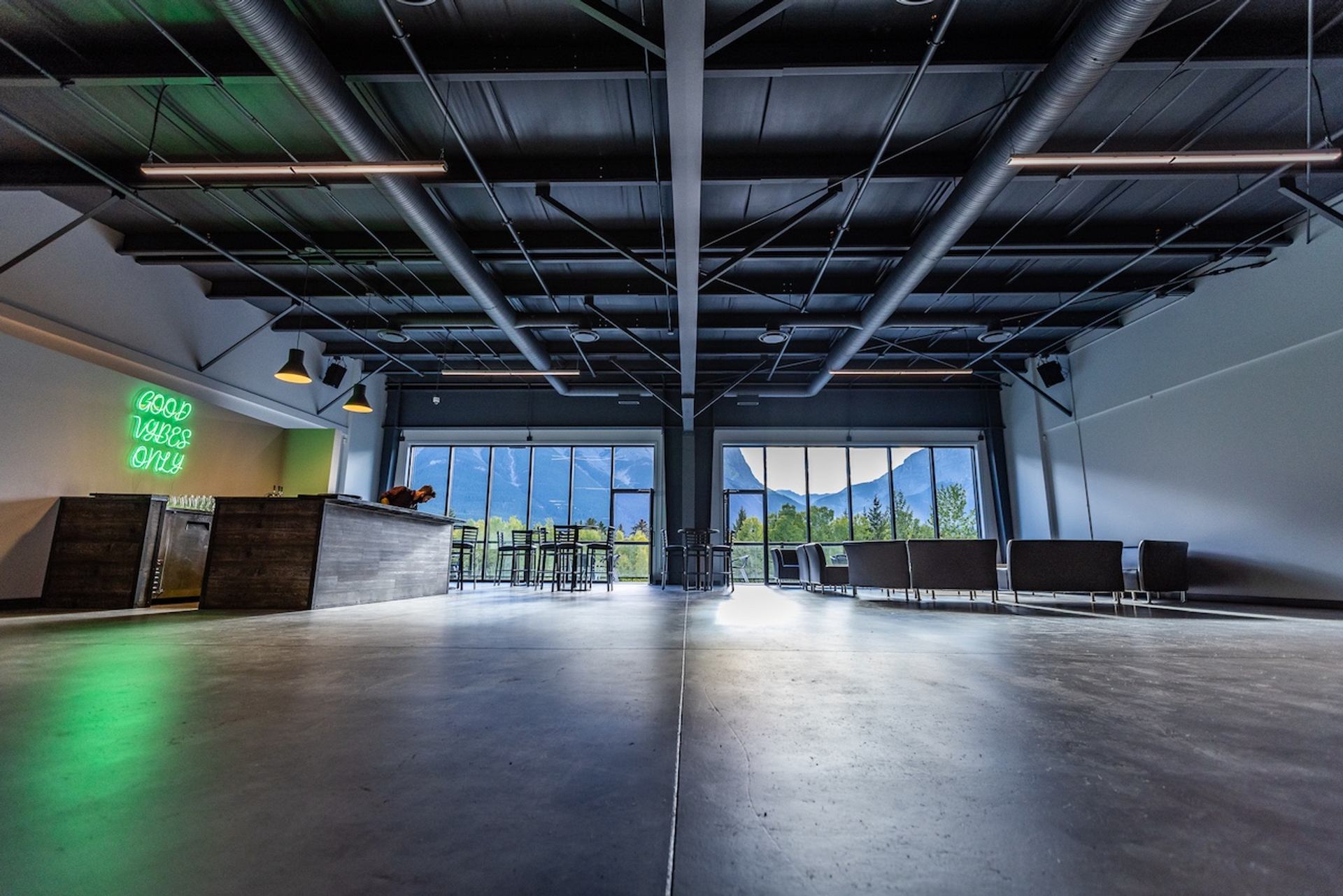 Large open event room with bar, seating areas, and mountain views