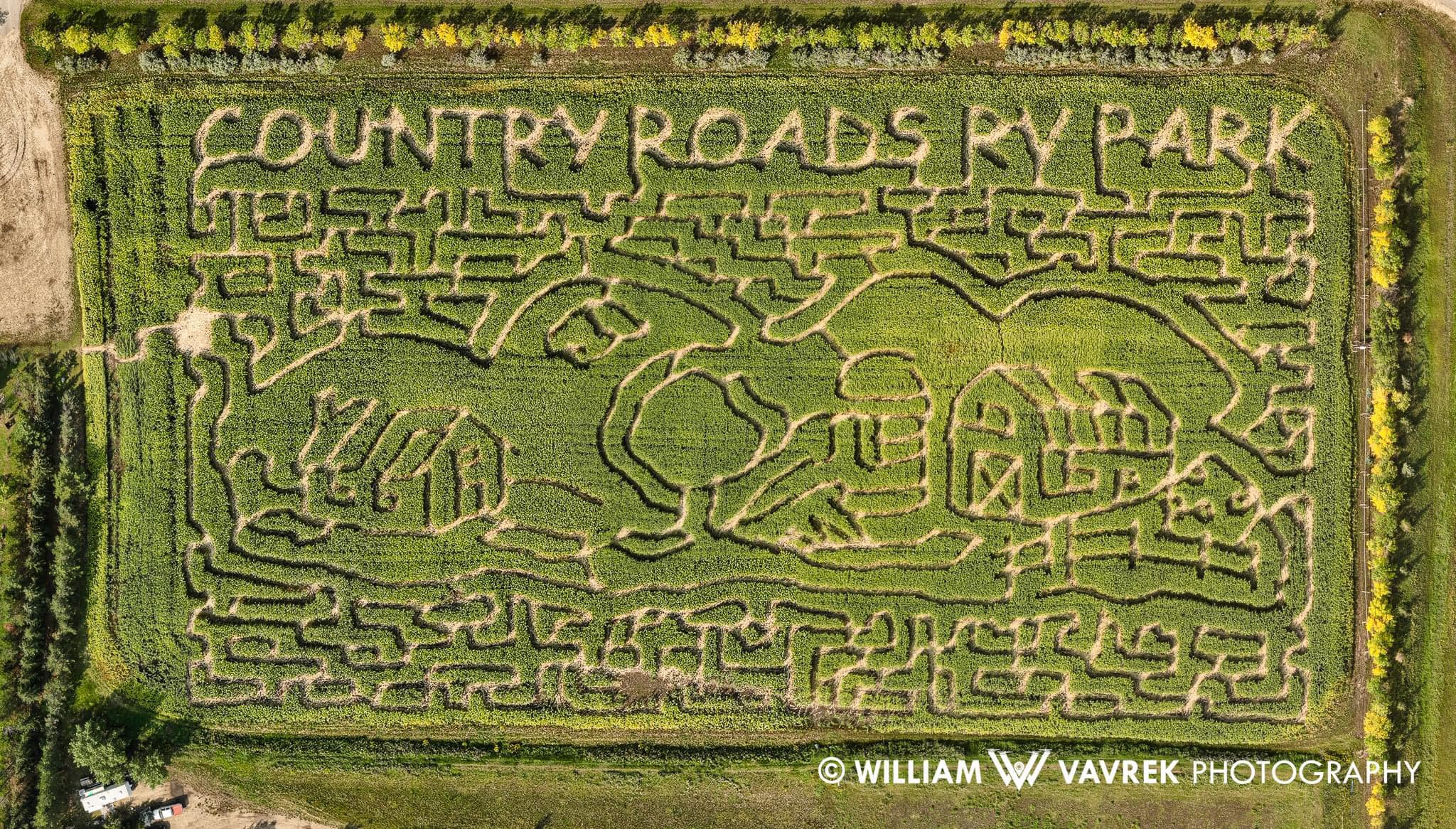 Aerial view of corn maze spelling COUNTRY ROADS RV PARK with barn and tree shapes.