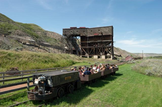 Group of people riding on a small train at the Atlas Coal Mine National Historic Site.