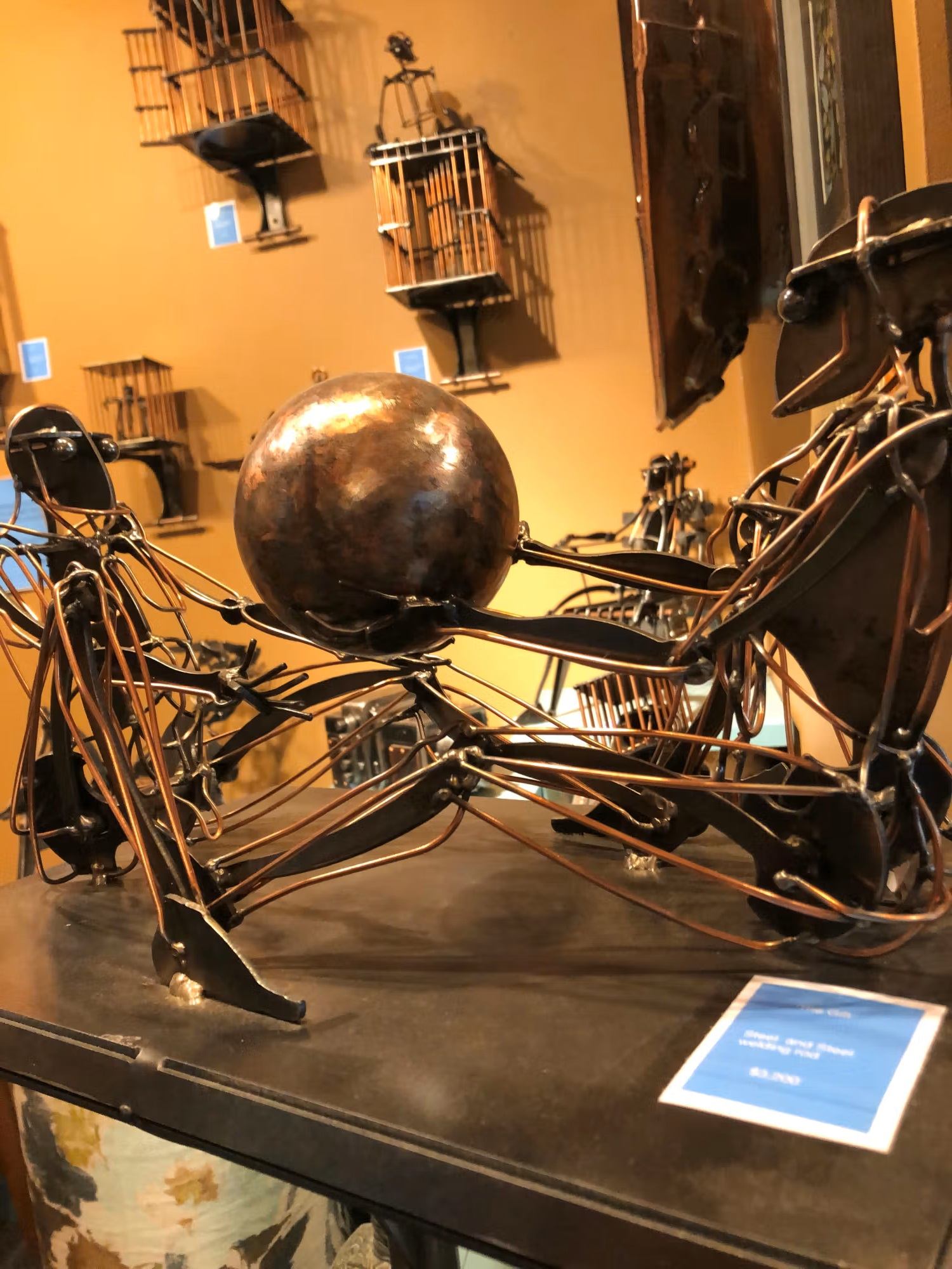 Metal sculpture of two abstract figures holding a sphere at Pike Studios.