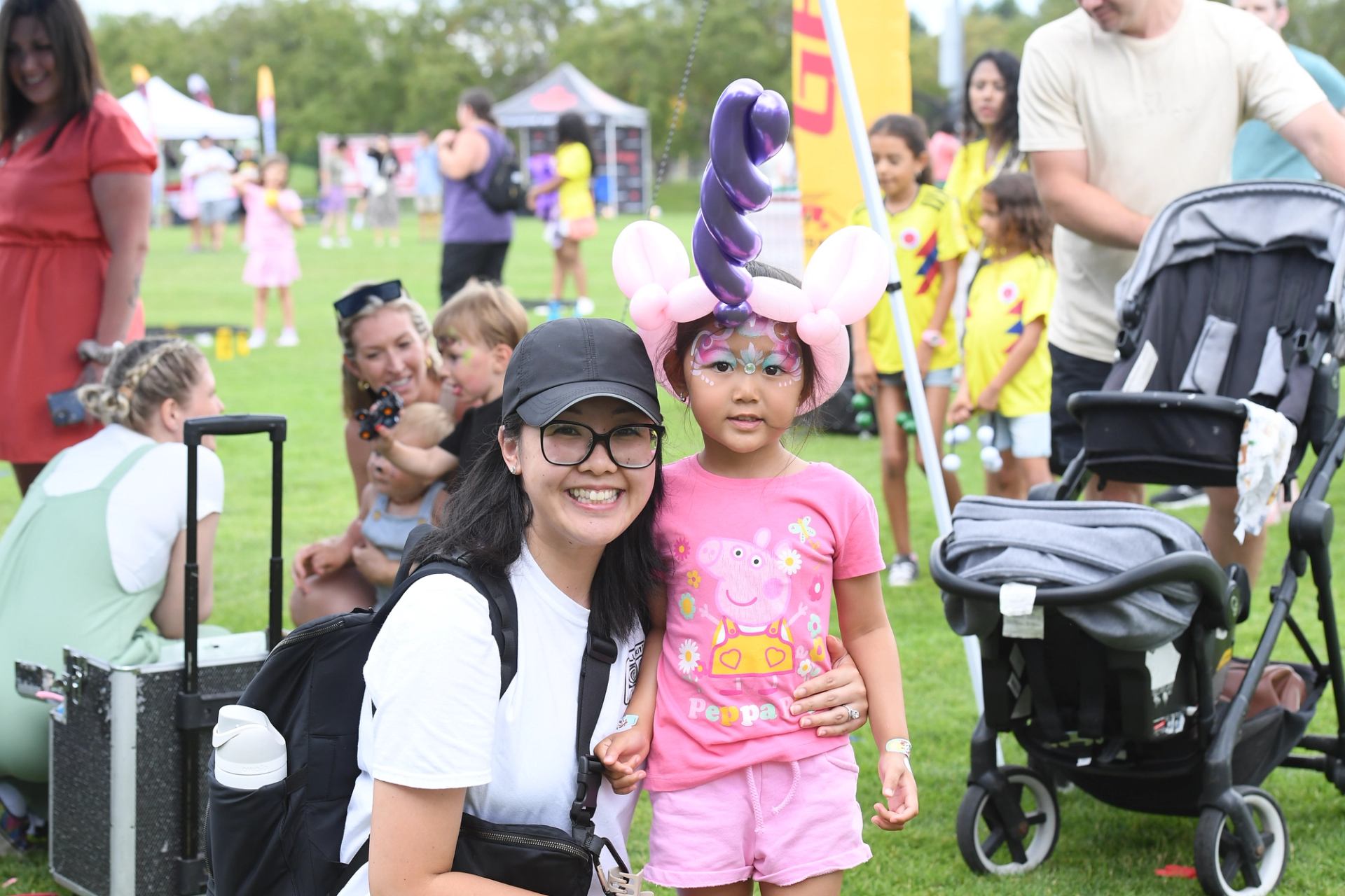 Two people pose at outdoor event, one in unicorn costume, at The Good Games.