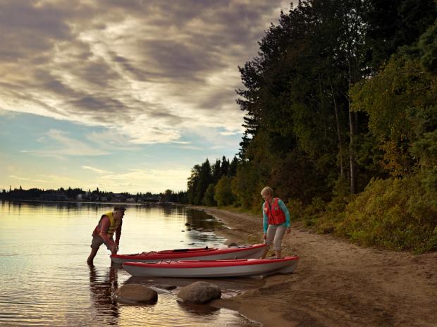 Older couple putting a kayak into Cold Lake.