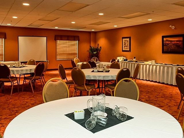 Banquet room with round tables, buffet setup, and warm lighting.