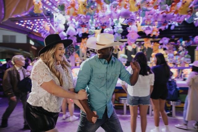 Couple walking through the midway at the Calgary Stampede.