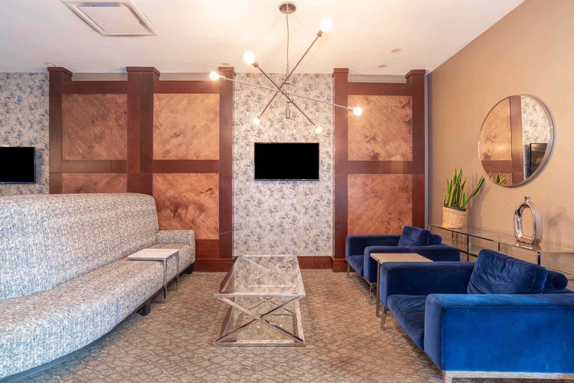 Lobby seating area with modern chairs, artwork, and warm lighting.
