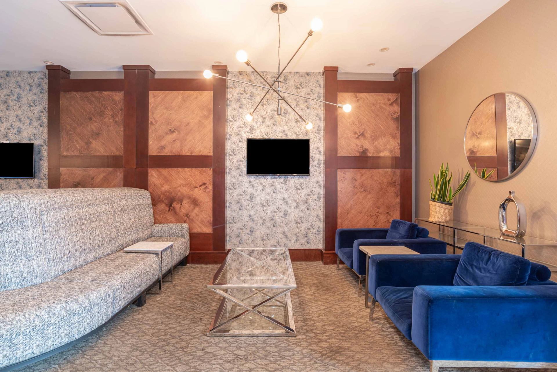 Lobby seating area with modern chairs, artwork, and warm lighting.
