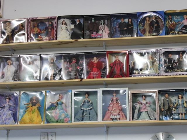 Shelves lined with collectible dolls in boxes displayed at The Treasure Chest store.