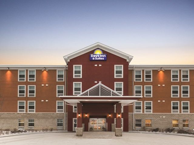 Days Inn & Suites hotel exterior with covered entrance and snow-covered parking lot.