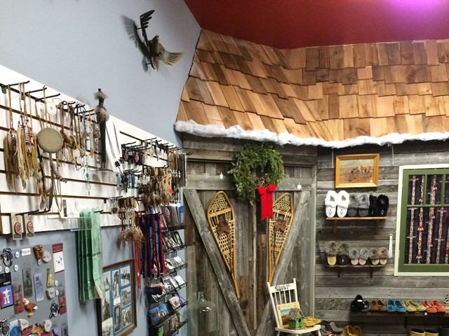 A rustic store featuring a wooden door and shelves filled with souvenirs and jewelry, showcasing its charming decor.