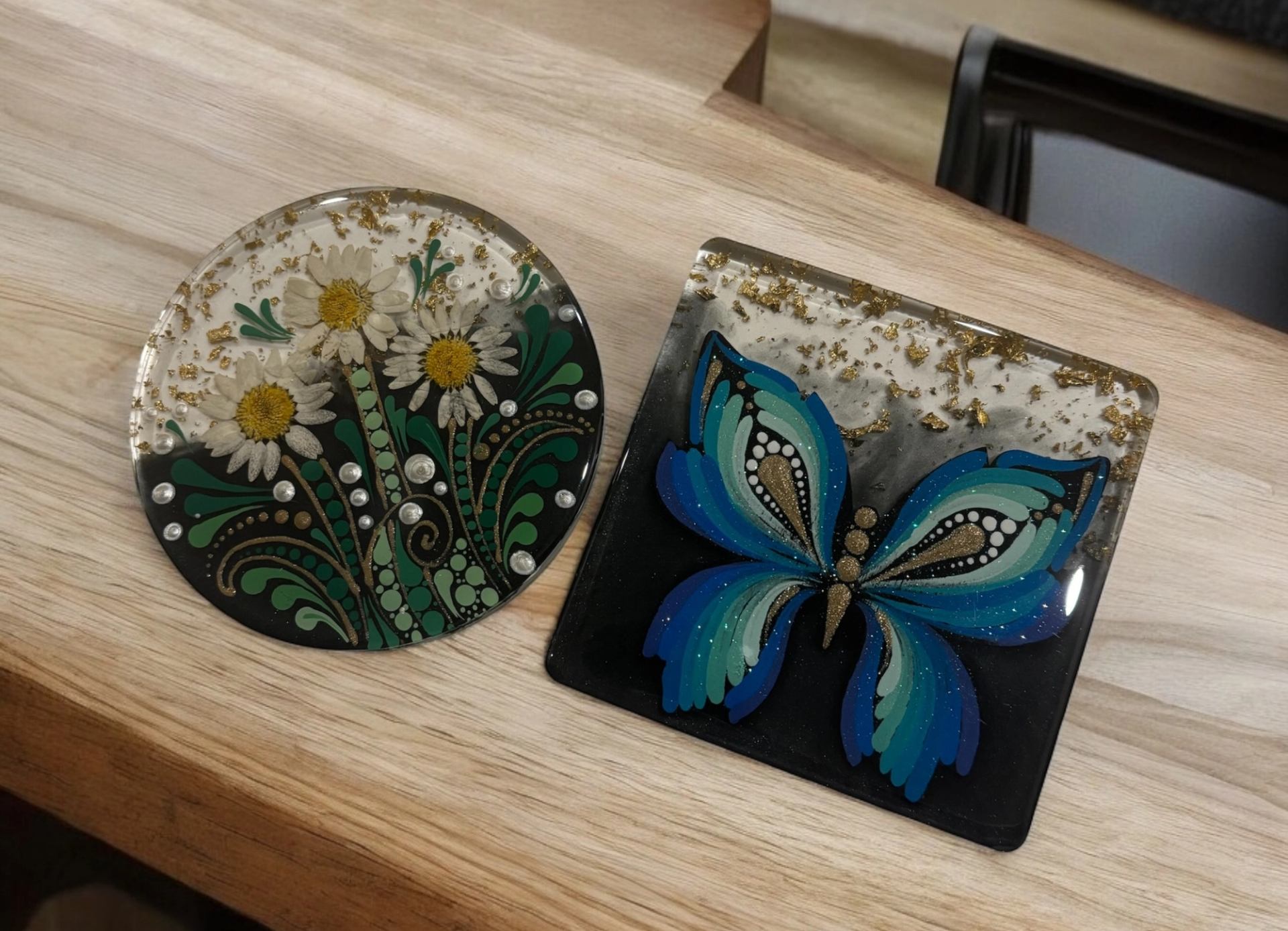 Resin art with daisies and a blue butterfly on wood background.