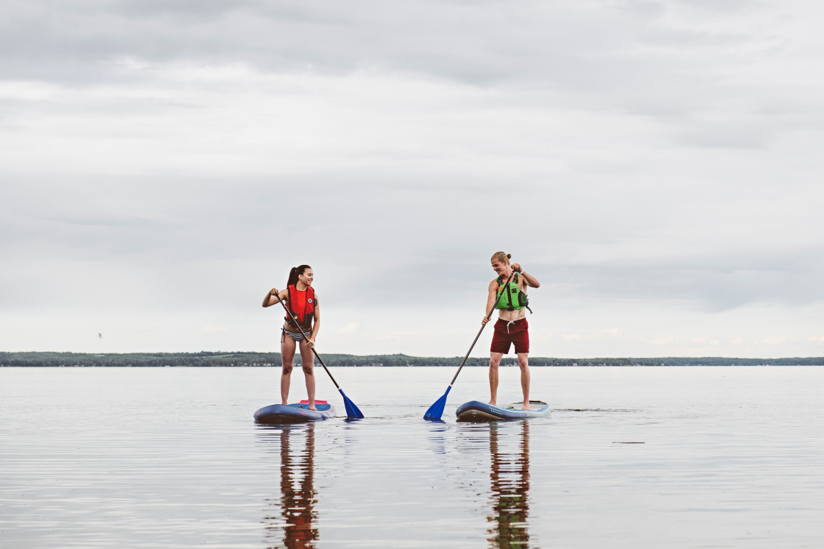 Two people stand up paddle boarding.