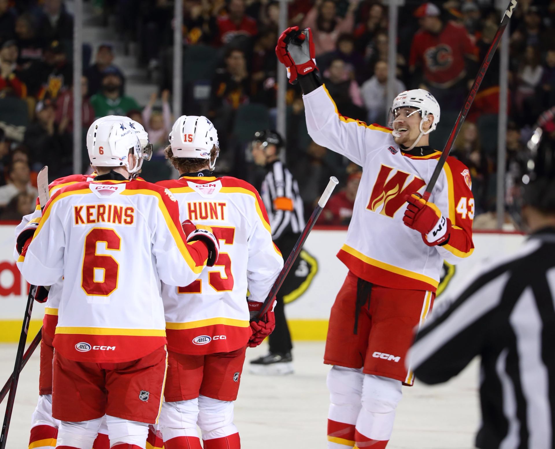 Calgary Wranglers wearing their home jerseys celebrating a goal.