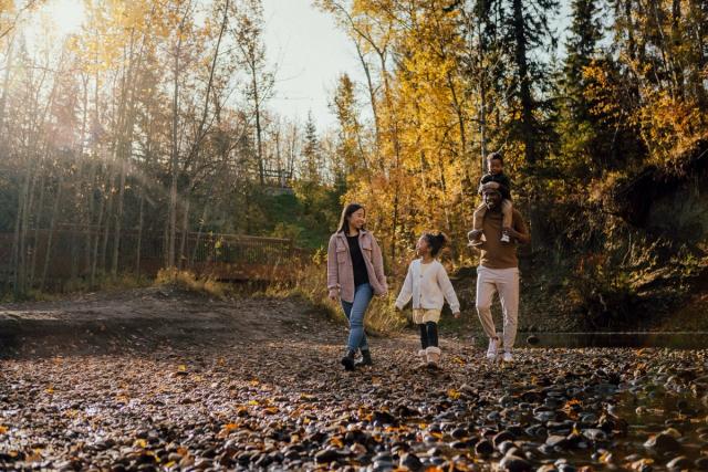 A mother and father walk along Mill Creek Ravine with two young children.