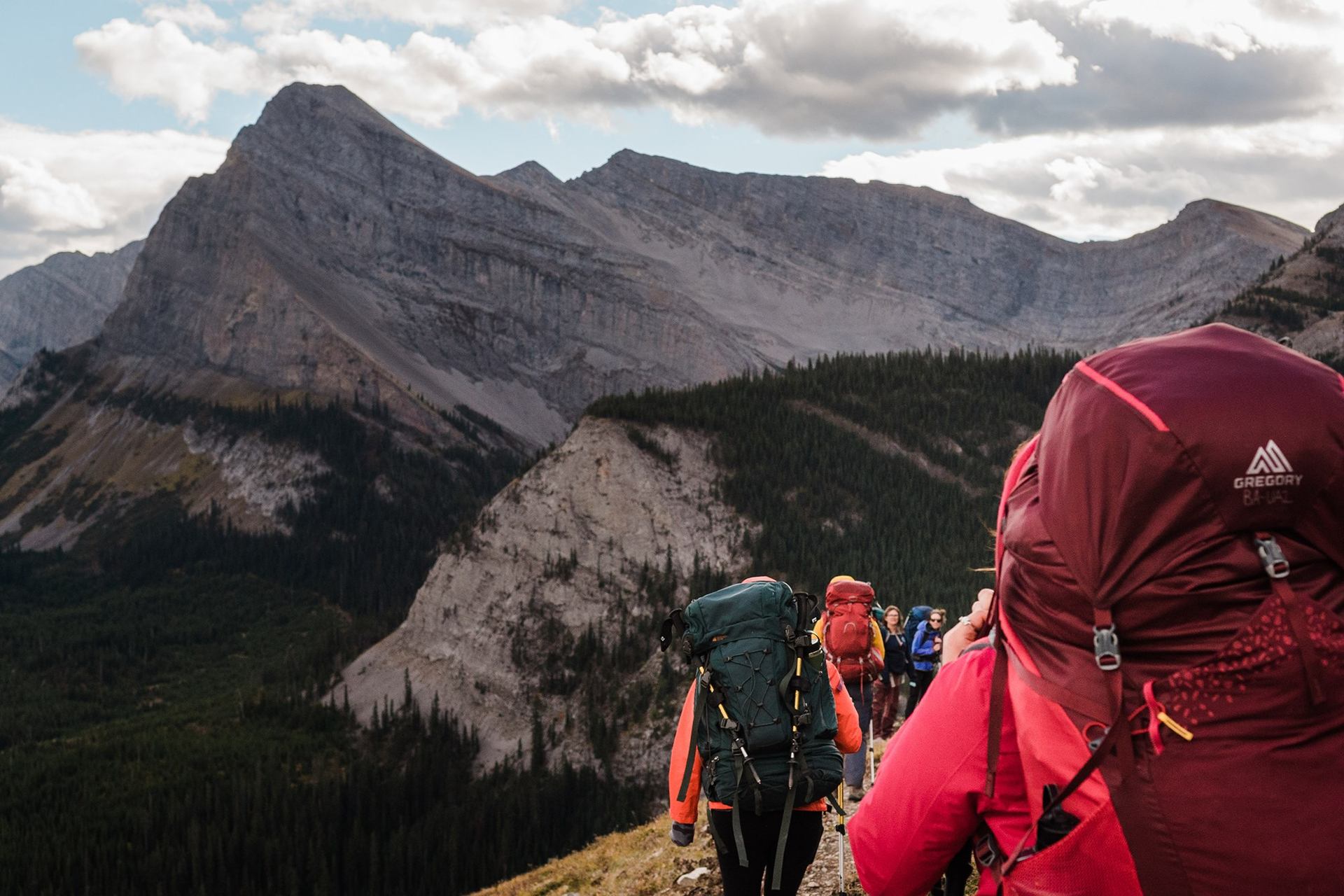 A group of people backpacking in the moutains.