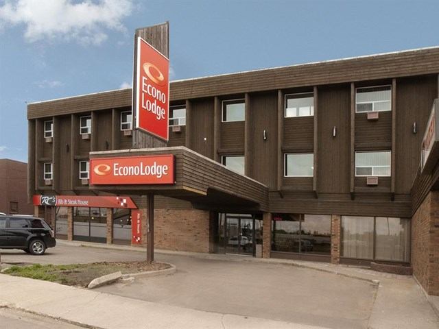 Econo Lodge Lloydminster exterior with red signage, brown facade, and parked vehicle.