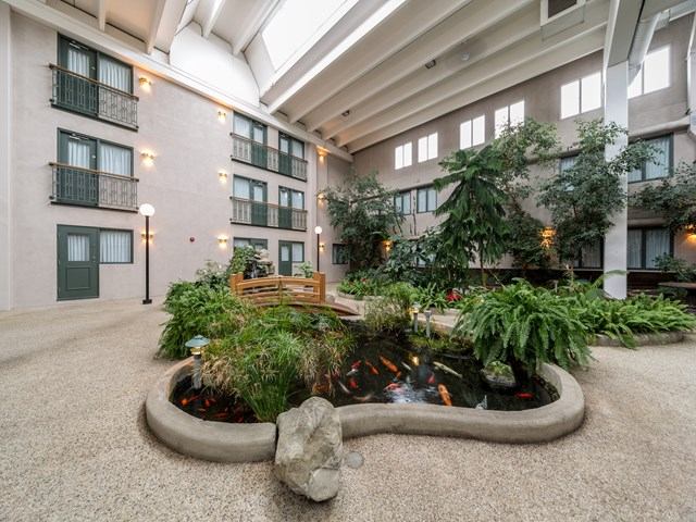 Indoor courtyard with koi pond, greenery, and seating at Heritage Inn Hotel.