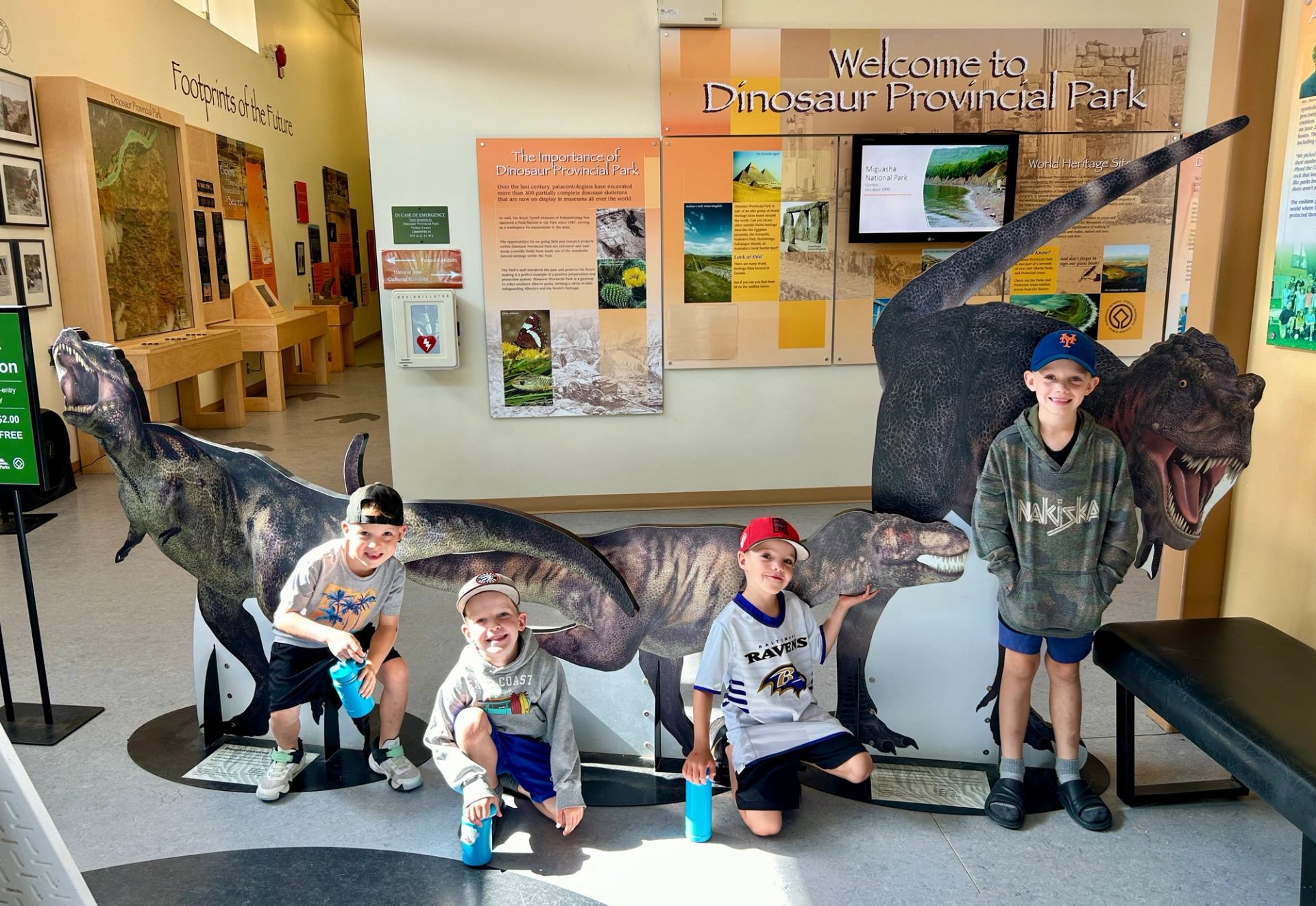 Children pose with dinosaur displays inside the Dinosaur Provincial Park visitor centre.