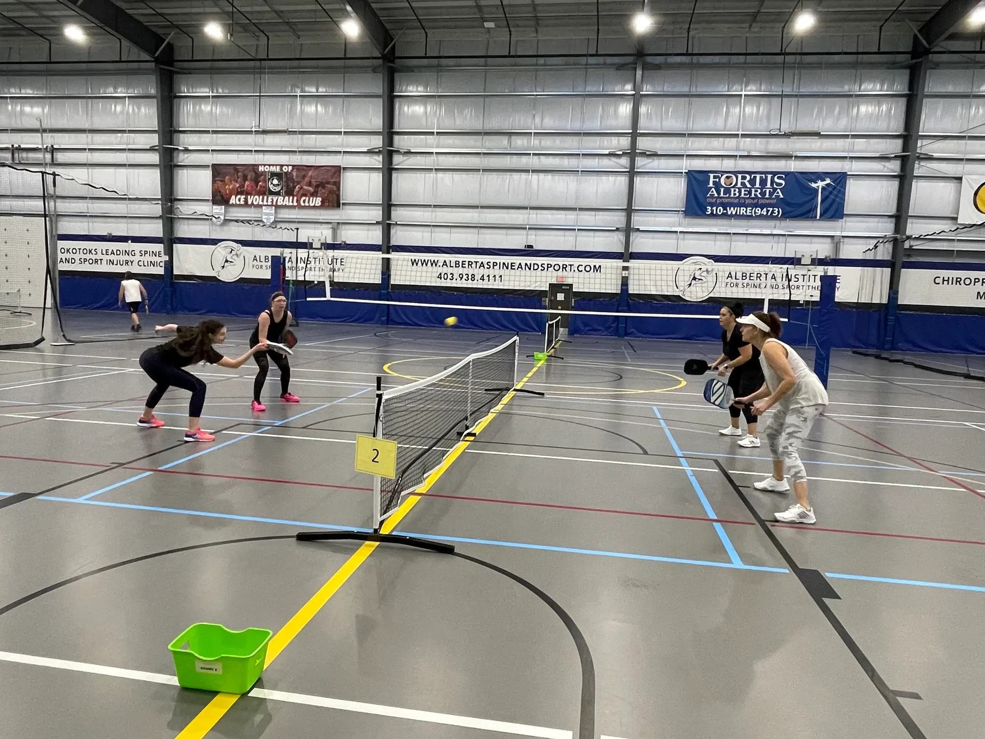 Four people playing pickleball at Regional Field House indoor court.