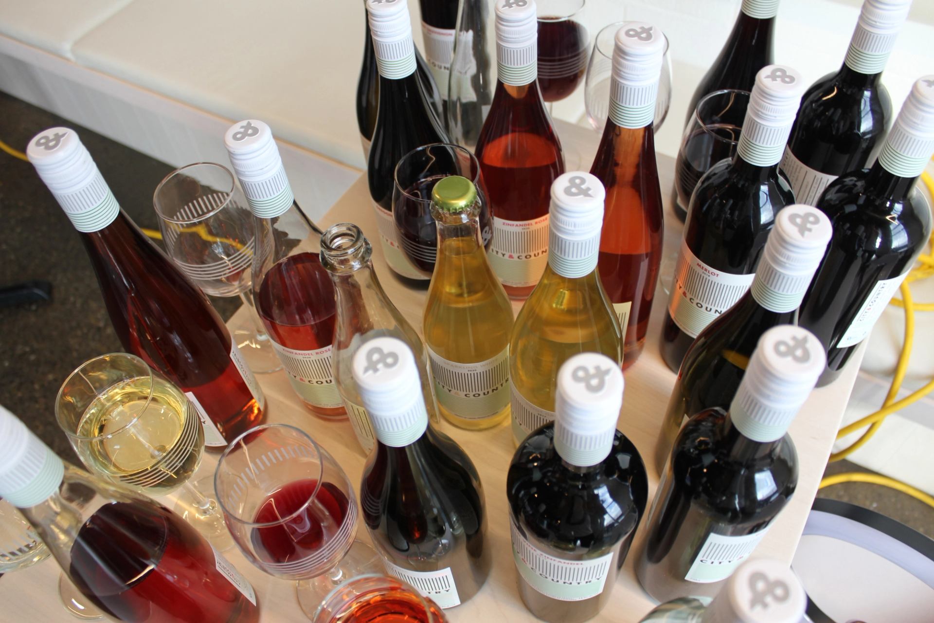 Assorted wine bottles and glasses on display at City & Country Urban Winery.