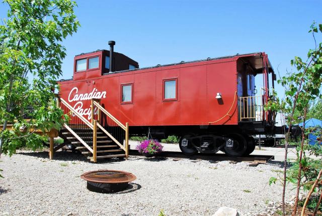 Exterior of an Aspen Crossing Caboose Cabin with firepit in front.