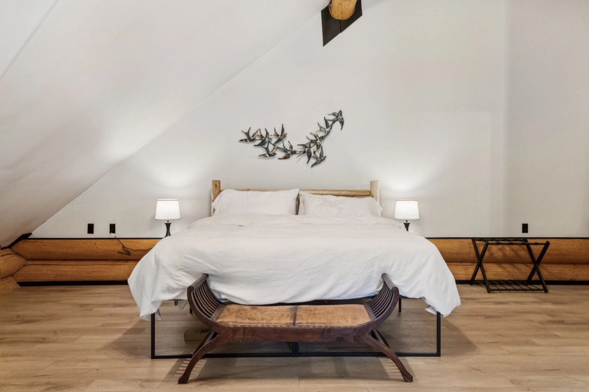 Cozy loft bedroom with white bedding and wood accents.