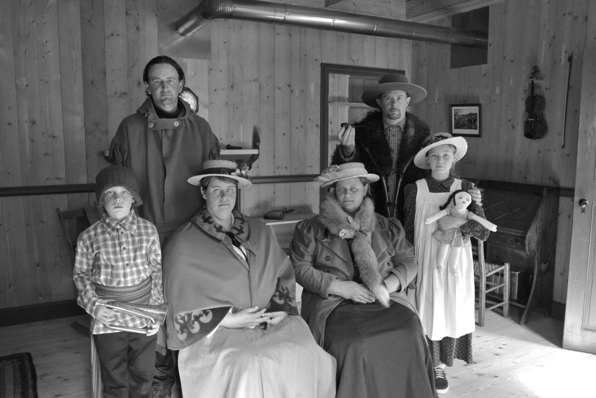 Group in period clothing posing inside a historic building at Historic Dunvegan.