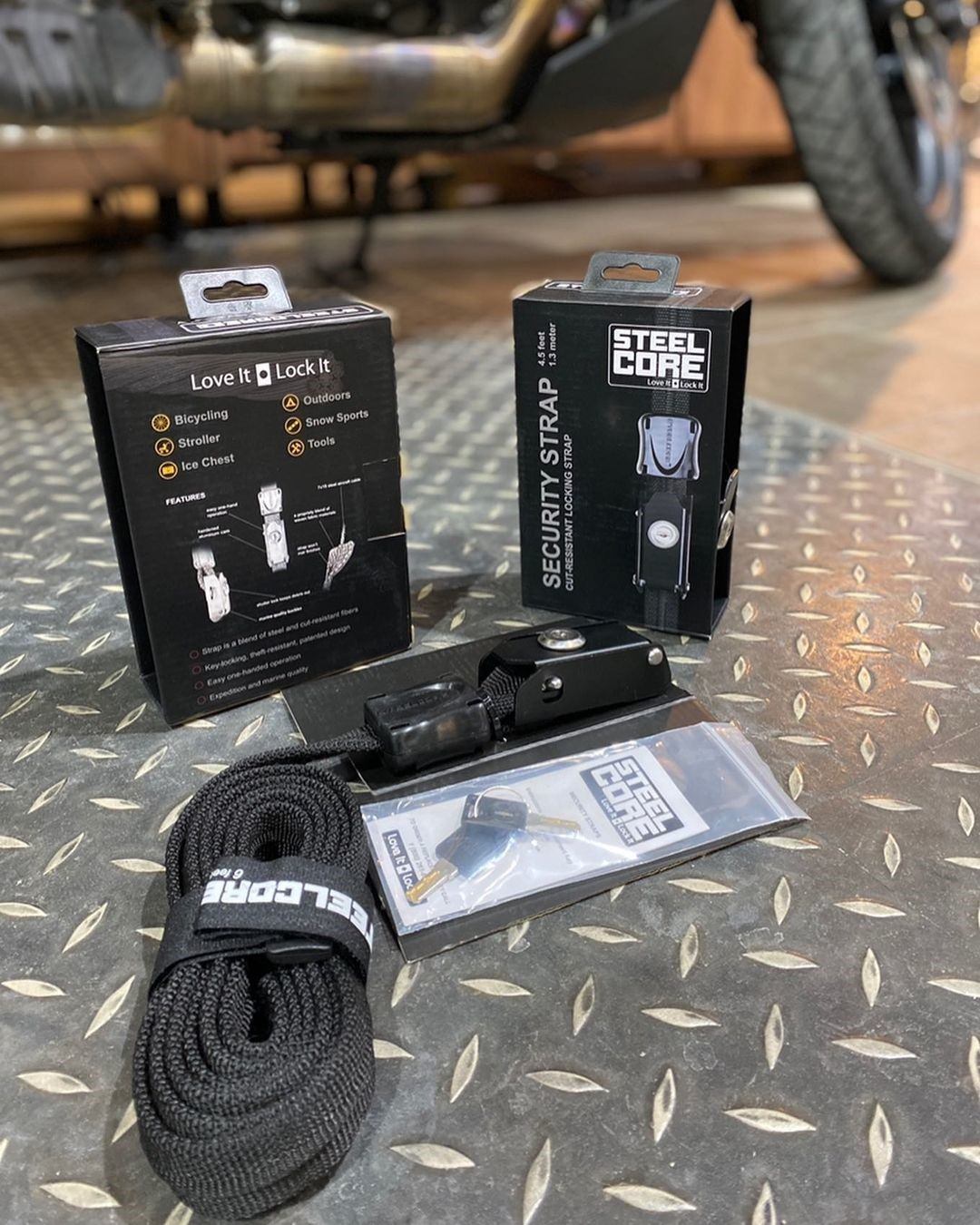 Steelcore security strap packaging, coiled strap, lock and keys on diamond plate floor.