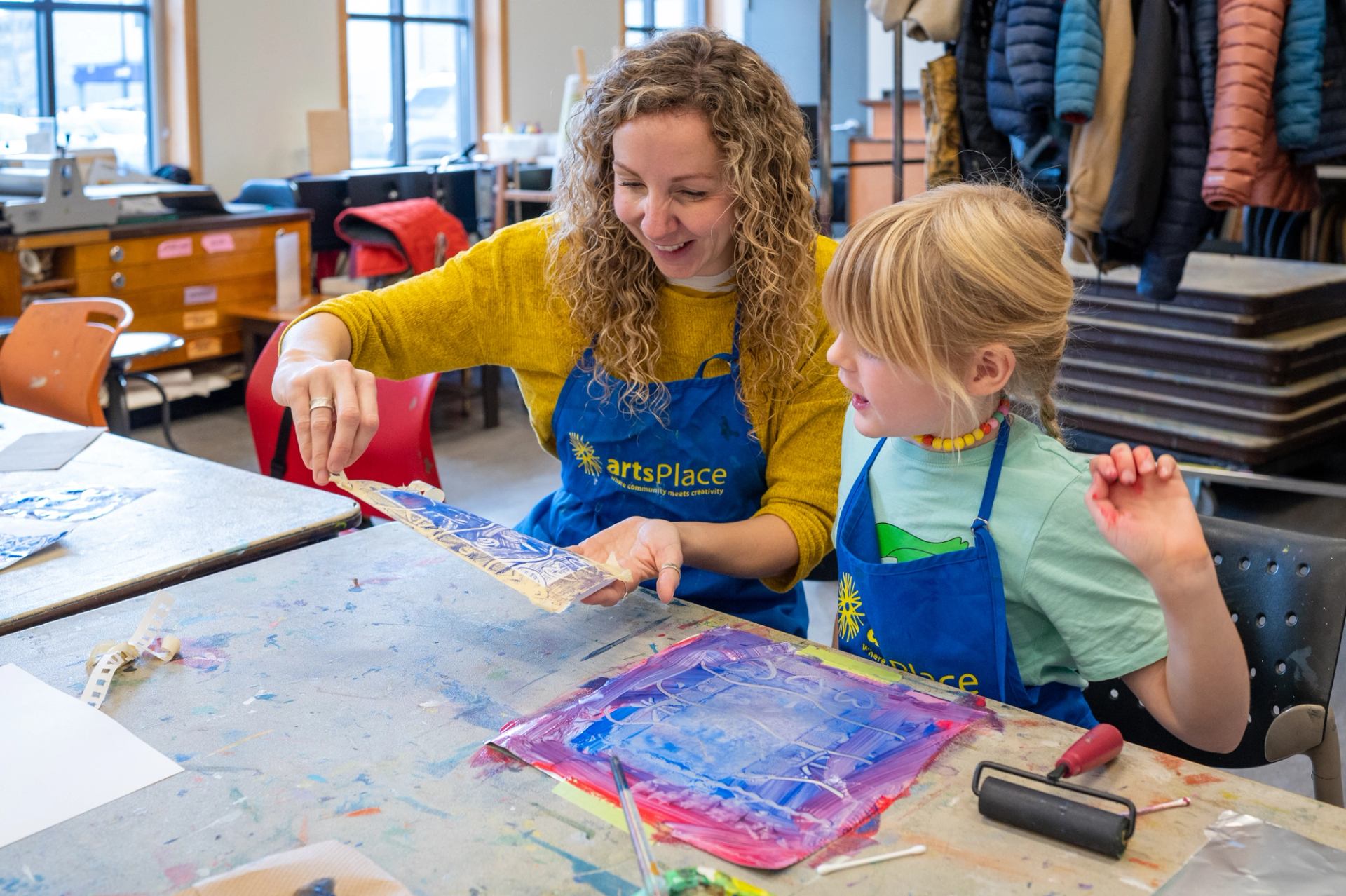 A woman looks at a painting made by her child.