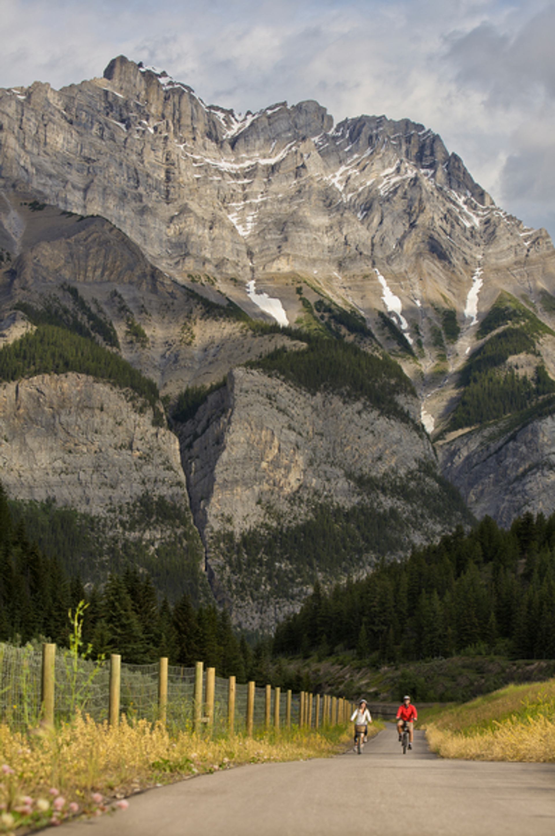 Wide shot of couple riding bikes on Legacy Trail in Banff National Park