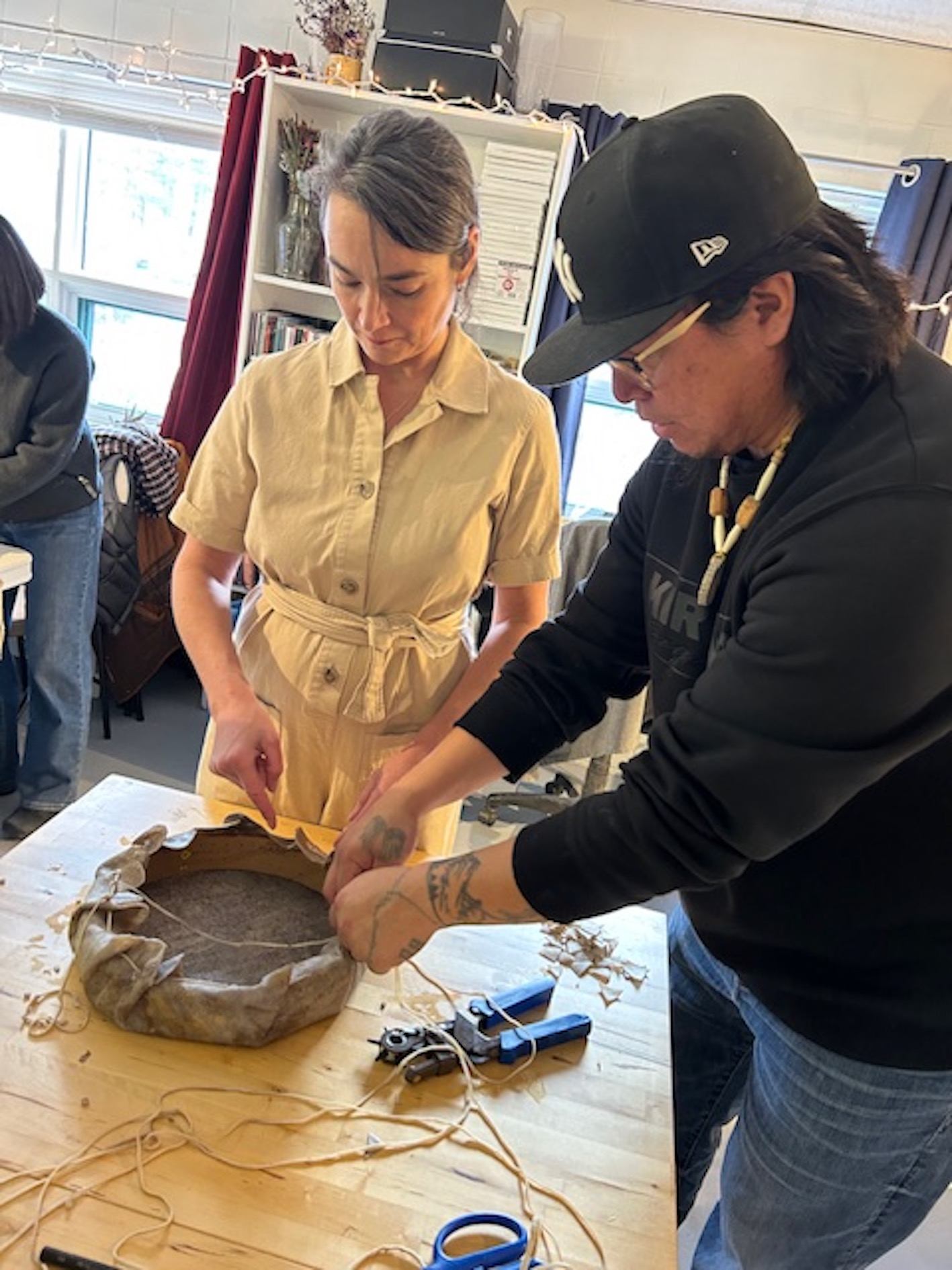 Stoney Artist Jarron Poucette showing participants how to make Drums