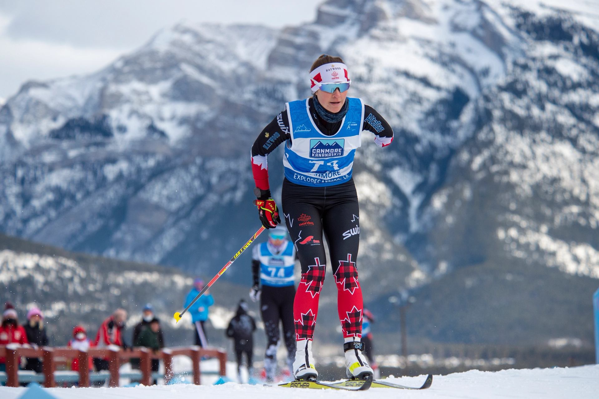 Para biathlete racing with snowy mountains in the background.