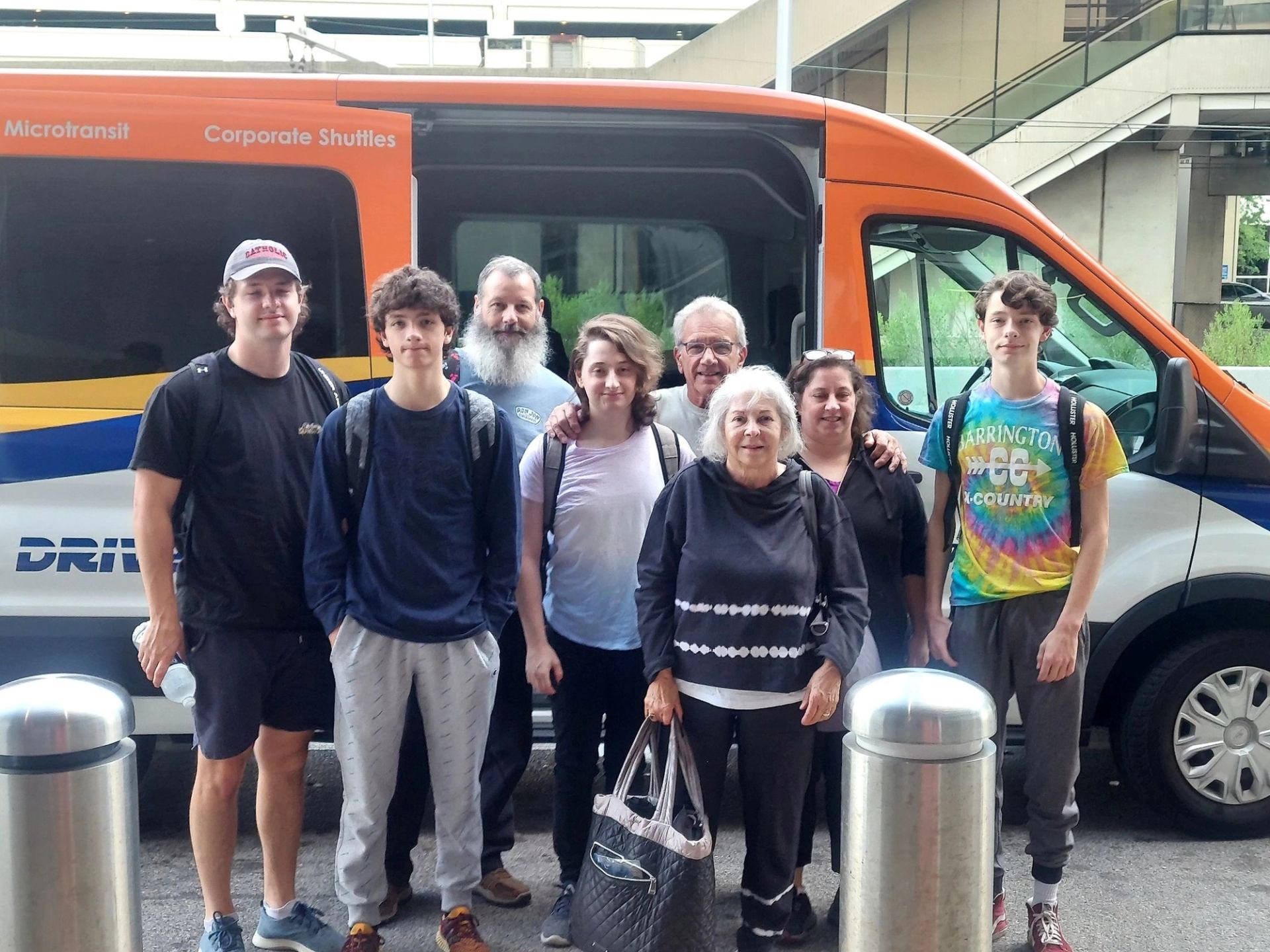 Group posing in front of Driverseat corporate shuttle van.