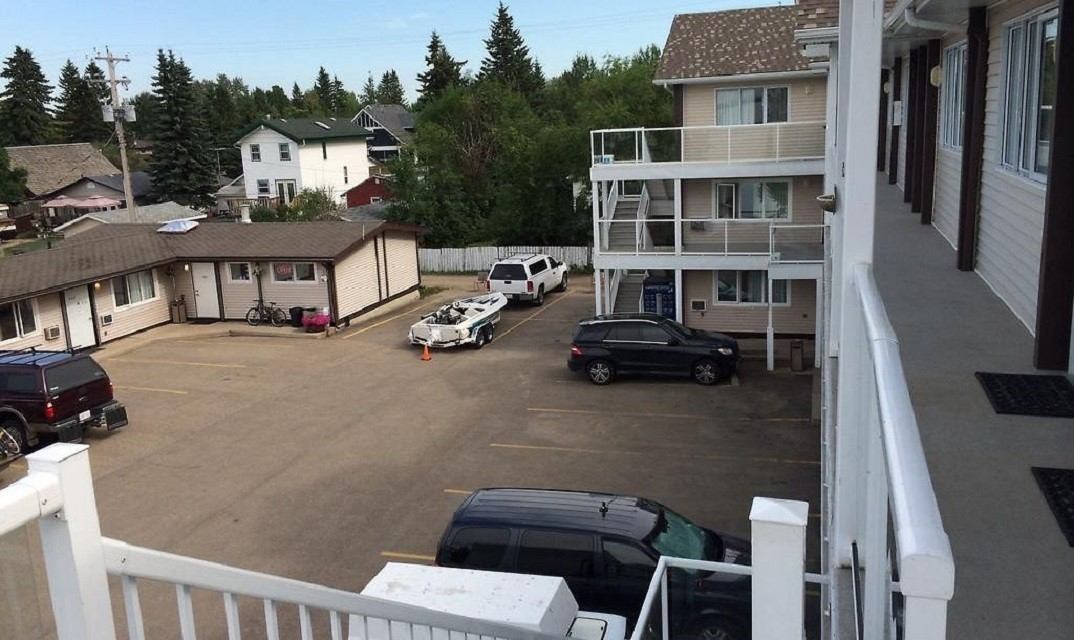 Parking lot view at Racoon Lodge Motel with cars and nearby buildings.