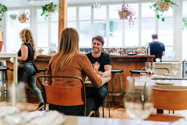 Couple eating a meal and drinking at Ten Foot Henery in Calgary.