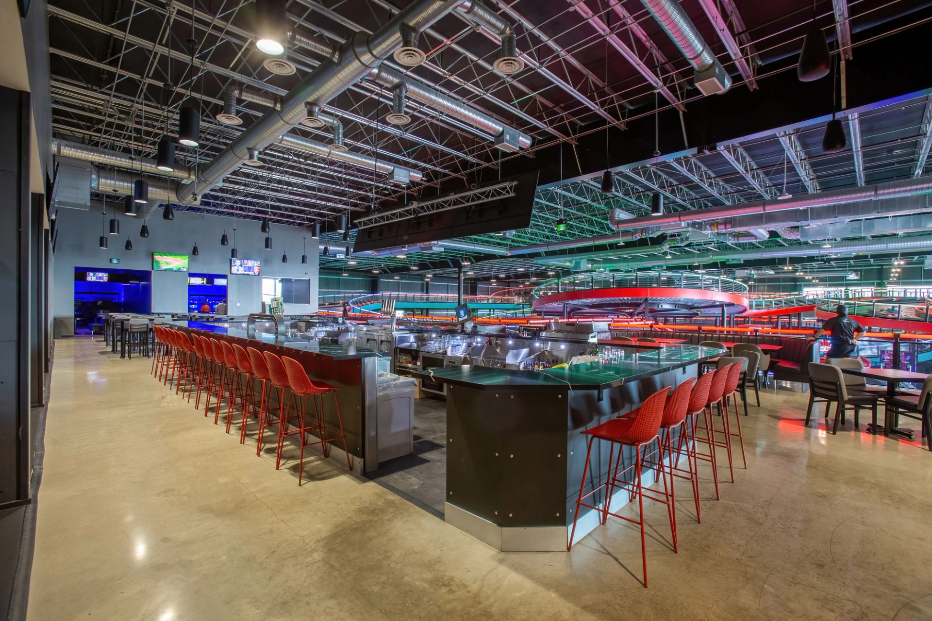 Modern indoor lounge at Speeders with sleek bar seating and colorful track lights in the background.