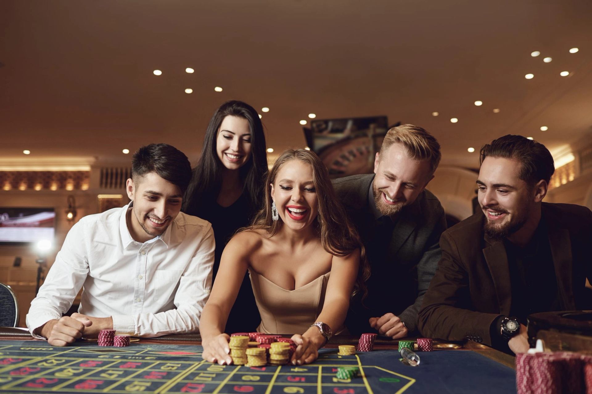Five guests gather around a casino table with colorful chips during a lively gaming experience.