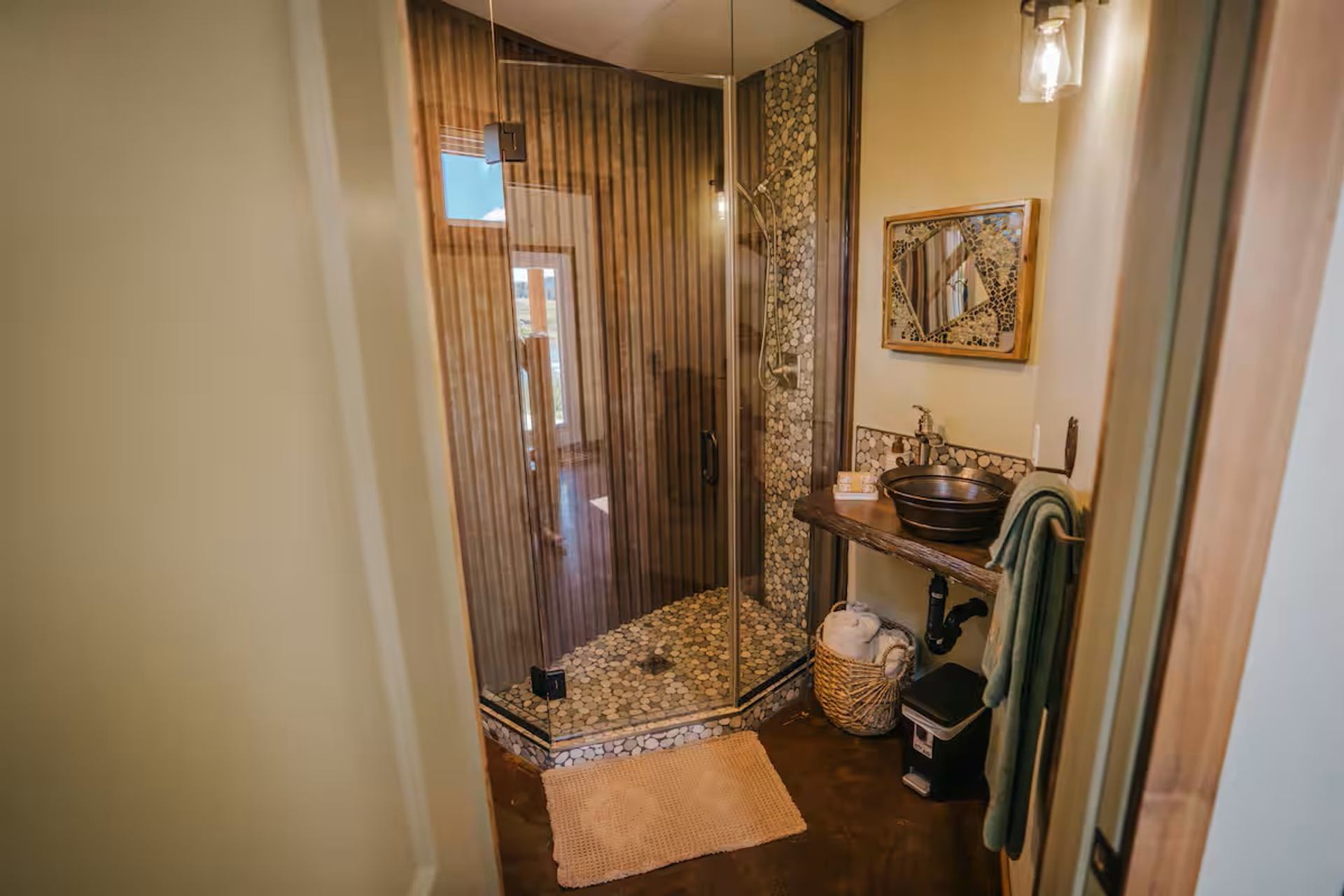 Saddle Hill Ranch bathroom with glass shower, stone accents, and rustic vanity.