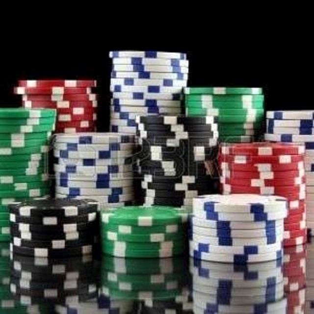 Stacks of colorful casino chips arranged on a reflective black surface.