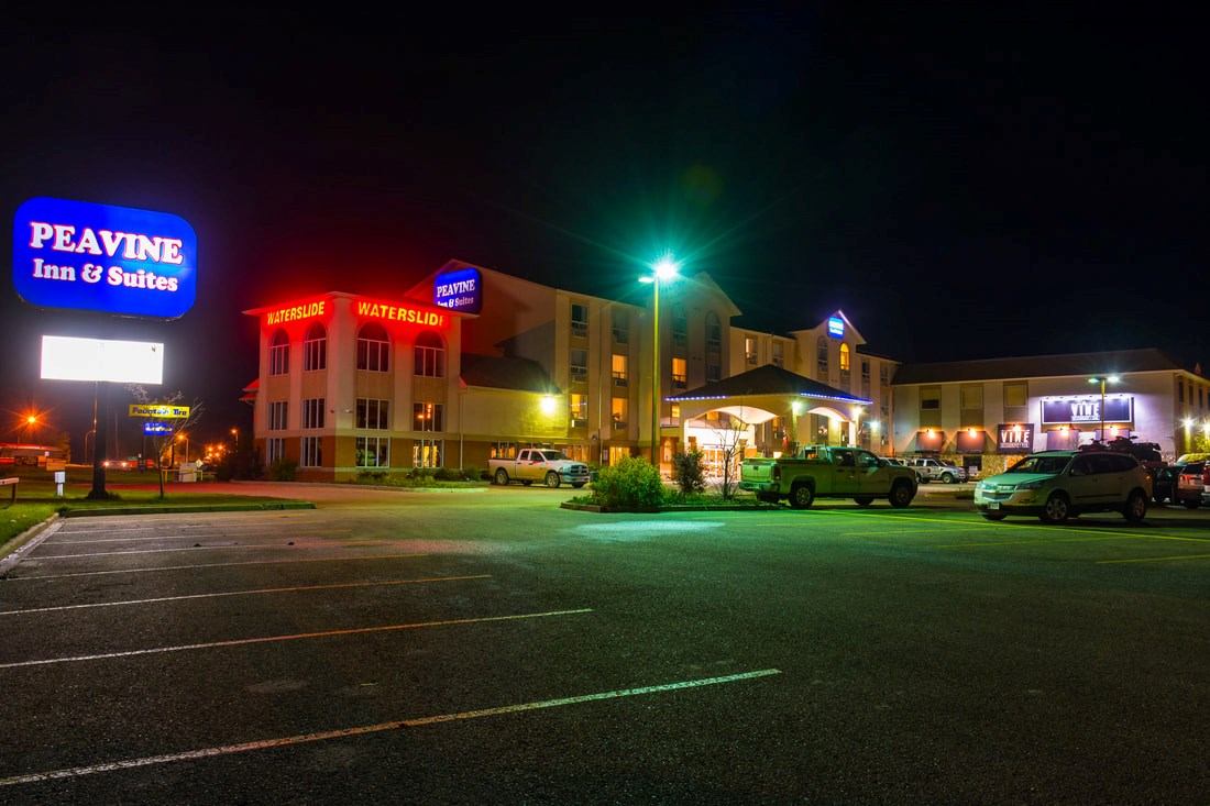 Night view of Peavine Inn & Suites with bright signage and well-lit entrance.