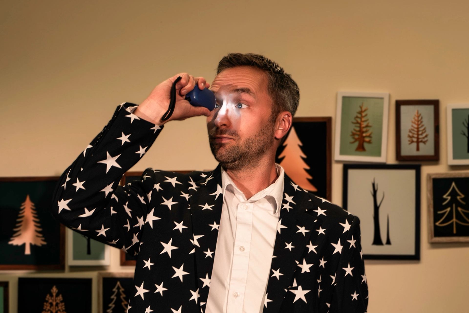 Performer in a star print suit holding a prop onstage