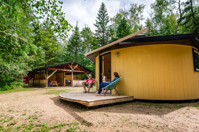 Family sitting outside of a Yurt at Elk Island Retreat.