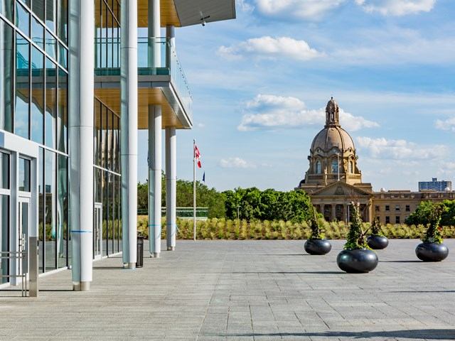 Glass Visitor Centre beside Alberta’s historic domed Legislature building and plaza.