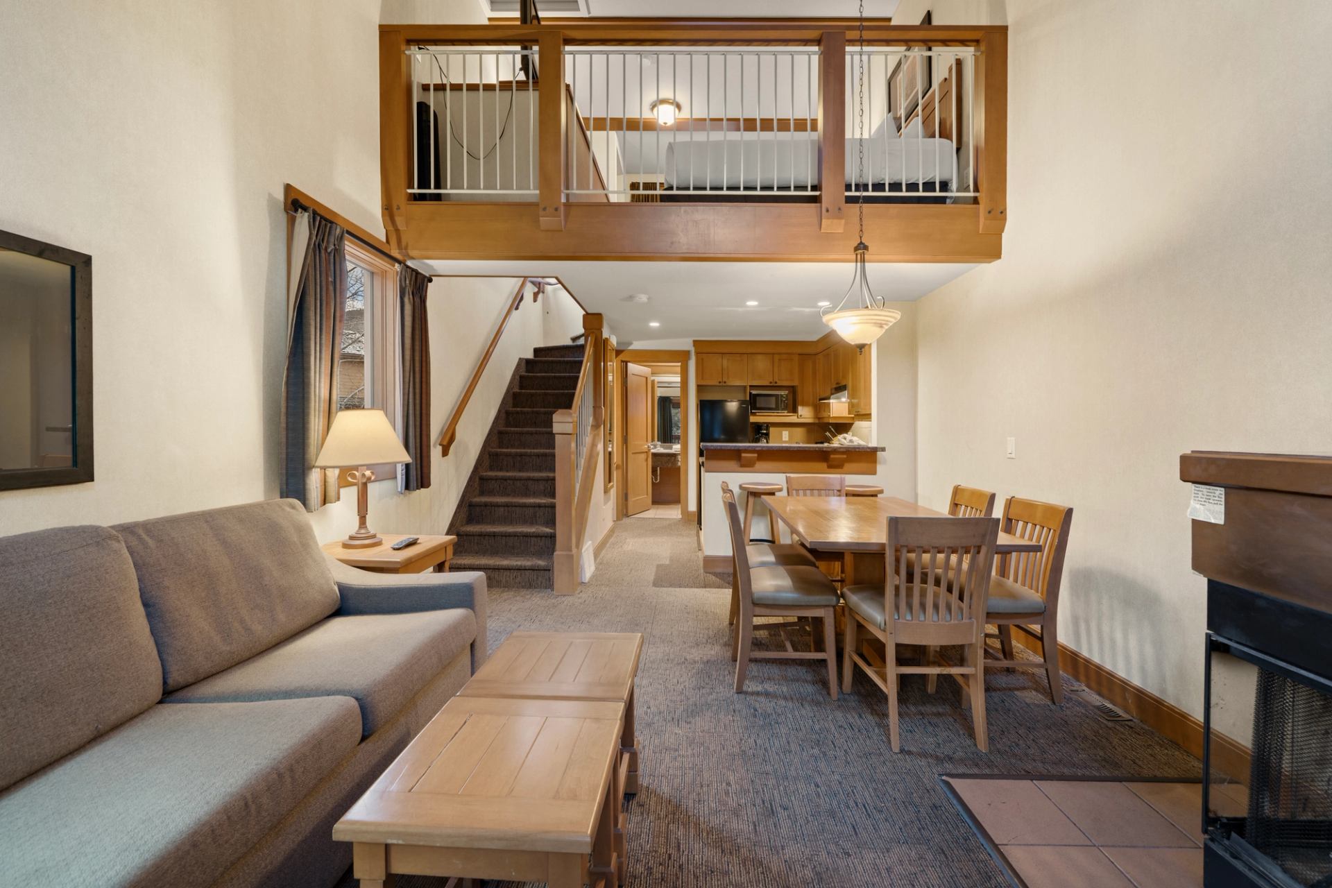 Condo with a loft, including a kitchen, dining area, and seating area with a fireplace.