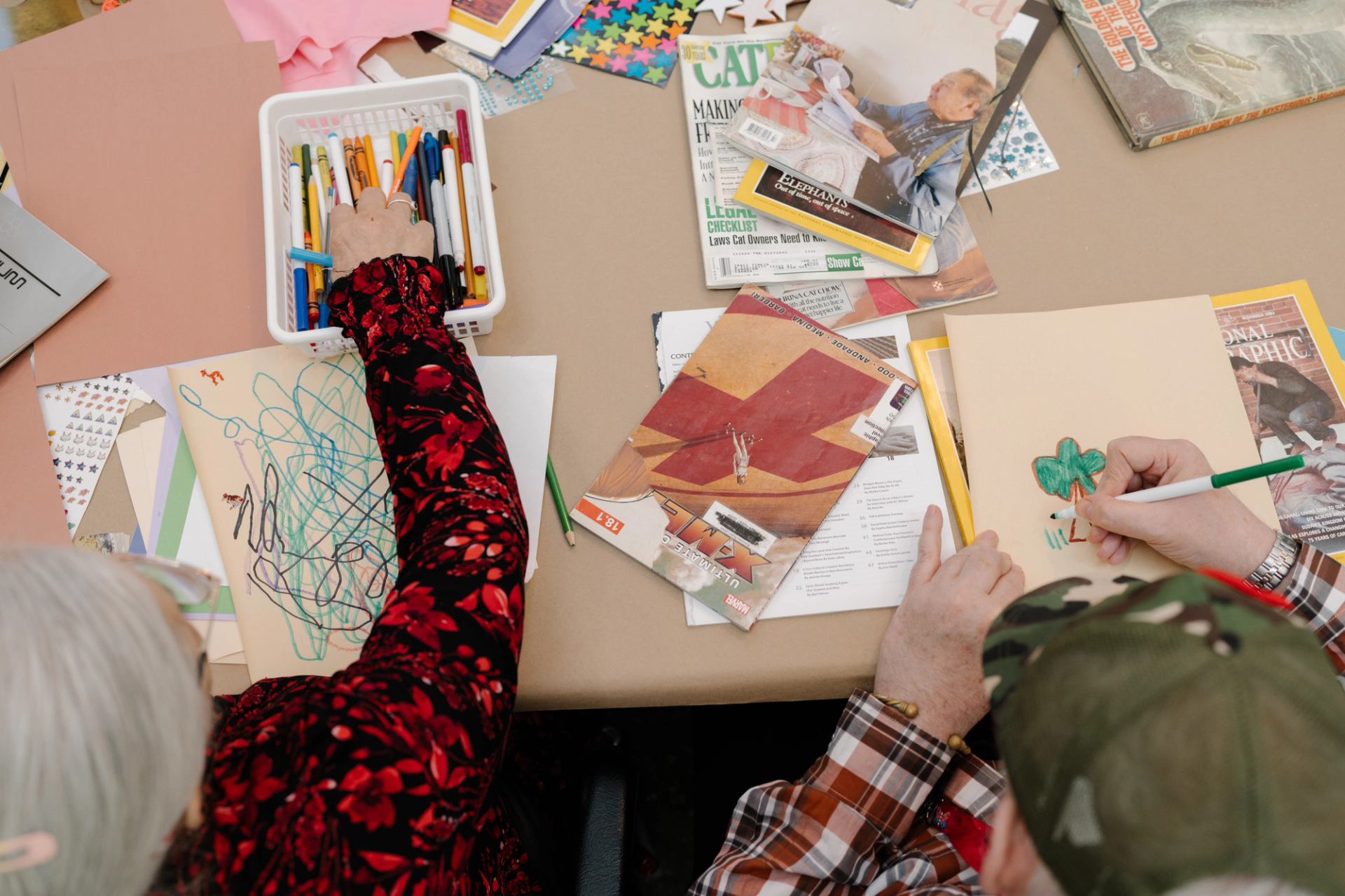 Two elderly participants work on drawings at a Mitchell Art Gallery event