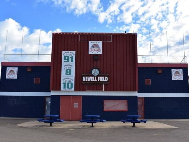 Little League park scoreboard and field signage on Ron Morgan Little League Park building.