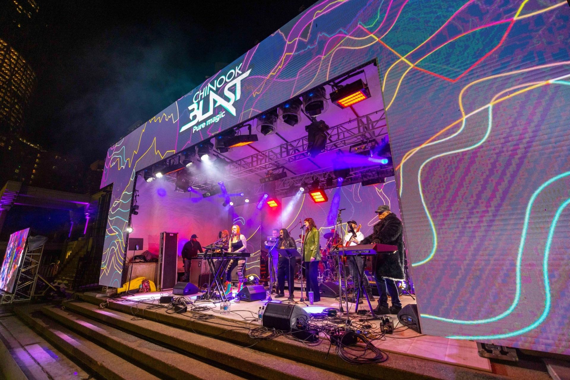 Band performing on stage under colorful lights