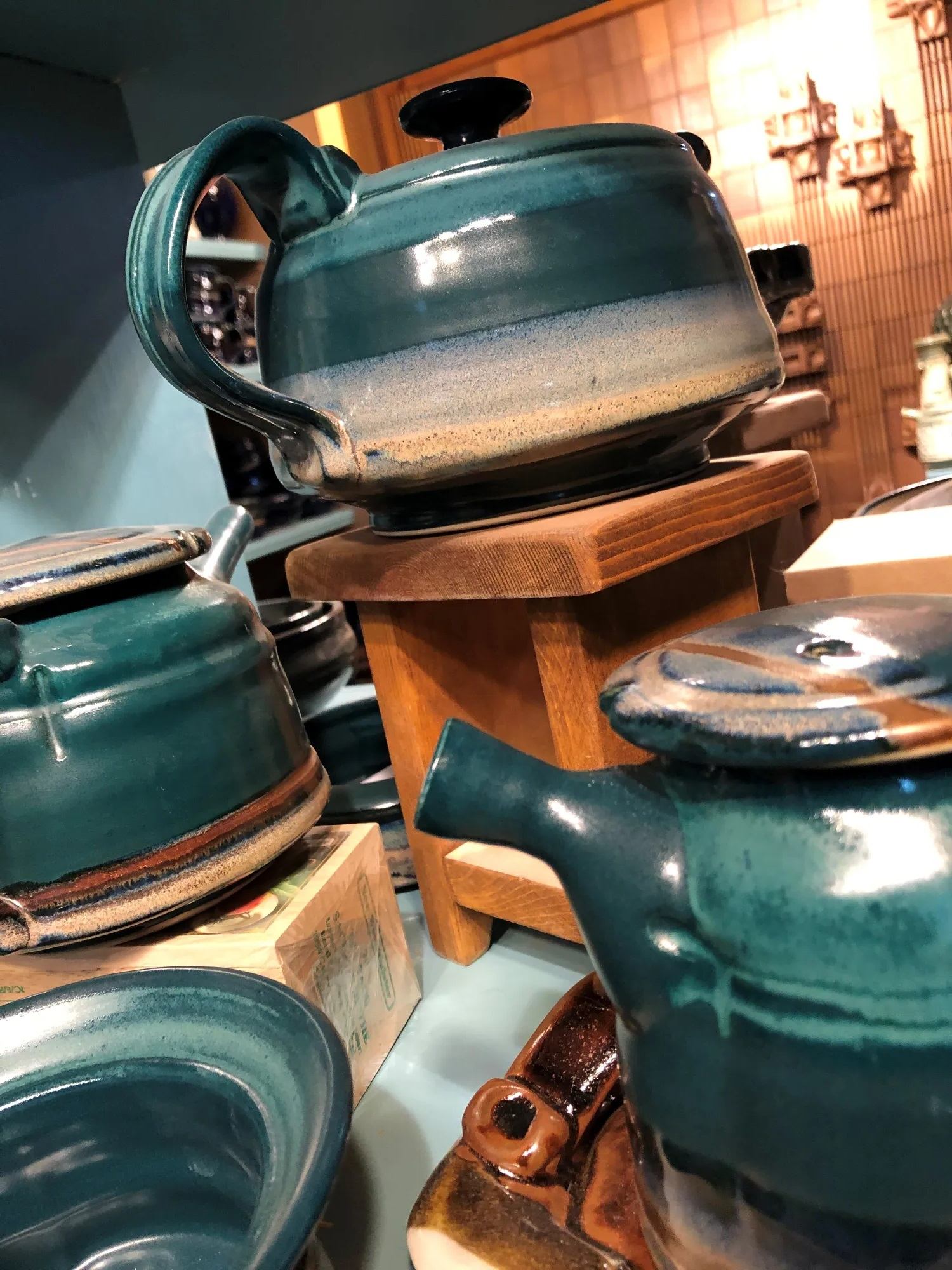 Close-up of handcrafted teal ceramic teapots displayed at Pike Studios.